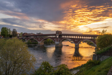 Fototapeta na wymiar Ponte Coperto (covered bridge) over Ticino river in Pavia at sunset, Lombardy, italy.