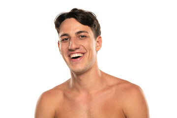 Fototapeta premium Closeup portrait of happy shirtless man 20s looking at camera isolated over white background