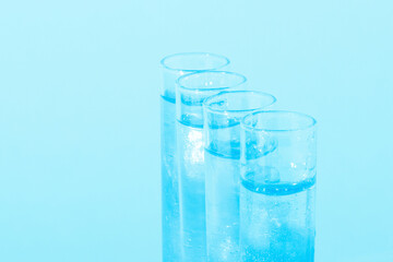 Glass flasks with liquid blue liquid. Glitter, varnish, liquid. Sequins. Laboratory research of cosmetics and liquids. Current naked gel.