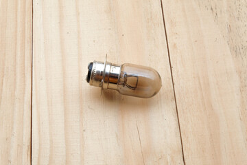 Old or broken light bulb on wood table.