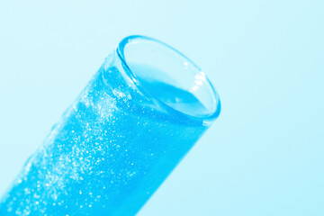 Glass flasks with liquid blue liquid. Glitter, varnish, liquid. Sequins. Laboratory research of cosmetics and liquids. Current naked gel.