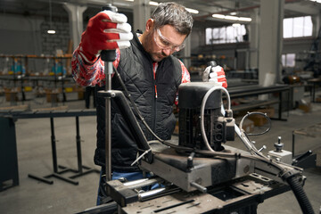 Obraz premium Adult male working on equipment in the workshop