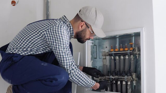 Heating engineer installing modern heating system in boiler room. Heating system and underfloor heating. Central heating