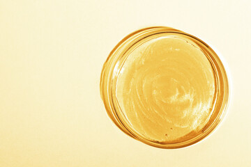 Liquid gold Or yellow liquid with sparkles. In a Petri dish. Laboratory research of cosmetics, gel, medicine. Chemistry