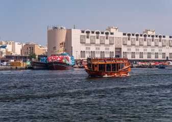 Obraz premium Tourists touring the Creek from Bur Dubai to Deira on a traditional dhow boat