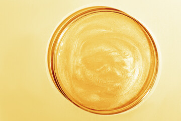Liquid gold Or yellow liquid with sparkles. In a Petri dish. Laboratory research of cosmetics, gel, medicine. Chemistry