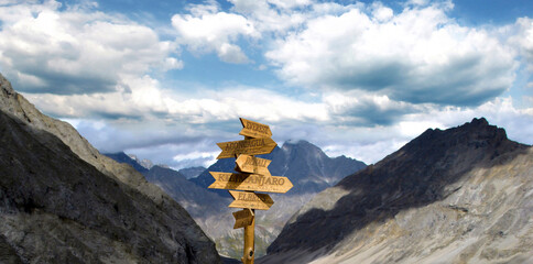 A road sign made of wooden arrows mounted on a log that indicate the direction to the mountain...