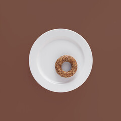 Homemade sesame and flax seed bagel on round white plate against maroon-brown isolated background. Minimal flat lay. Modern food pattern. Bakery concept.