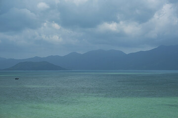 Fototapeta na wymiar Beautiful seascape. Calm ocean against misty mountains.