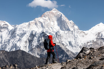 Hiker in red jacket admiring west face of Makalu (8481m) after crossing Kongma-la pass on Three passes trek