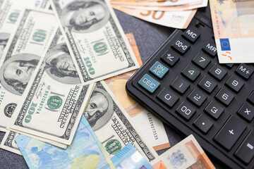 Euro and dollar notes. euro against dollar. A closer look of the president of the USA with a dollar bill, peeping out from behind a euro bill. USA and Europe finance relation. Close up top view.