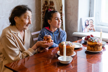 Fototapeta na wymiar Easter concept. Grandmother with granddaughter are holding Easter eggs at home