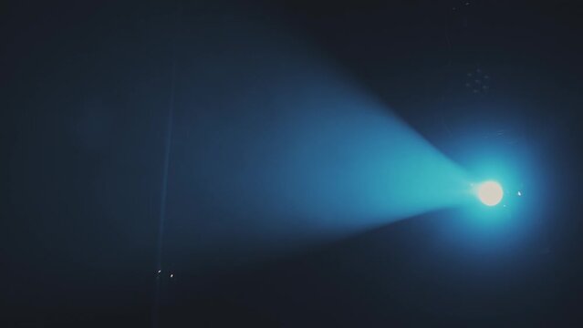 Scene illumination with a profiled blue beam of a profile spotlight in the smoke from a smoke machine from top to bottom
