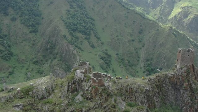 Aerial drone view of historical castle Mutso with travellers at the top of mountains in Khevsureti, Georgia