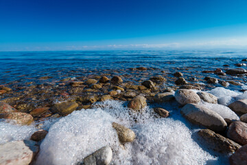 Fototapeta na wymiar Rocky shore with sea foam, Issyk-Kul, Kyrgyzstan