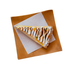 Lemon cheesecake tart or pie slice with fresh lemon curd meringue on wooden dish isolated.