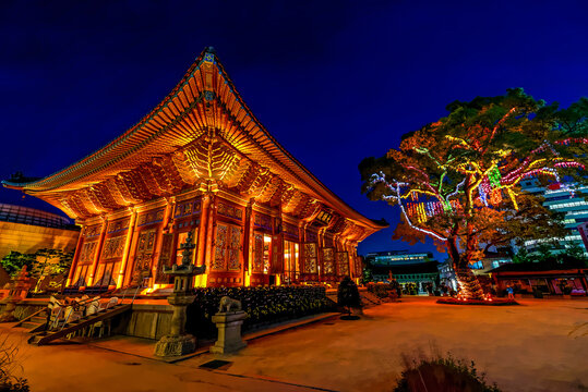 SEOUL, KOREA-SEPTEMBER 27, 2107: Famous Jogyesa Temple at night and decorated Chinese Scholar Tree. Sign translated: Daeungjeon - Main Dharma Hall. 