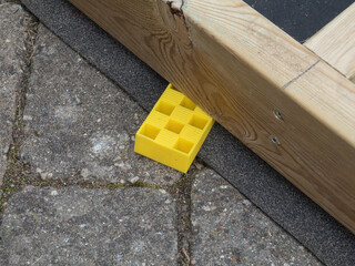 Impregnated timber wooden board stabilized with wedge of hard plastic.