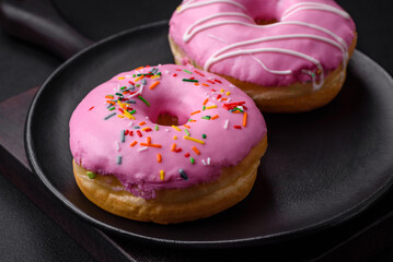 Delicious donut with cream filling and nuts on a dark concrete background