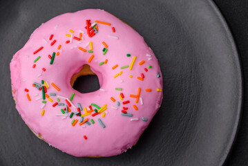 Delicious donut with cream filling and nuts on a dark concrete background