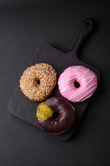 Delicious donut with cream filling and nuts on a dark concrete background