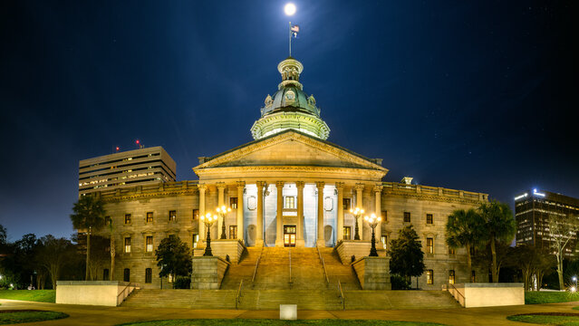 Illuminated South Carolina State House, in Columbia, SC, under a starry sky with a full moon. The South Carolina State House is the building housing the government of the U.S. state of South Carolina