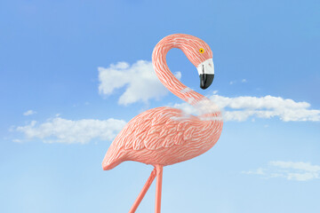 Summer surreal colorful scene with pink flamingo among white clouds against pastel blue sky background. Outdoor vacation party ornament. Creative card concept. Daydreaming wallpaper.