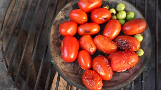 Tomatoes being roasted on comal plate