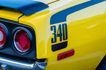 Rear quarter panel of a bright yellow muscle car