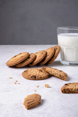 Close-up of baked oatmeal chocolate chip cookies and milk in a glass. Selective focus. Vertical orientation.