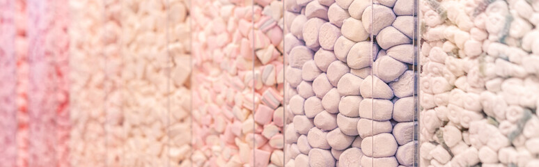 Pastel pink and purple marshmallows in a shop window. Food texture. Selective focus