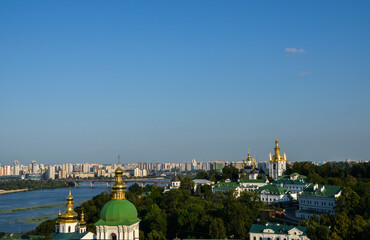 Fototapeta na wymiar The domes of the Kyiv Pechersk Lavra overlook the Dnipro River and the left-bank part of Kyiv, capital of Ukraine