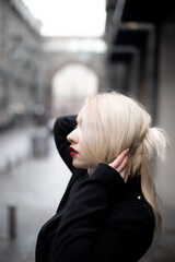 Fototapeta na wymiar blonde hair care daily products concept. flawless and neat hair. dreamy, pensive and romantic young woman walking in city.