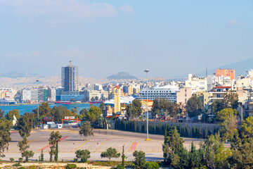 Obraz premium View of Athens, the Parthenon Temple and the Propylaea Gate on Acropolis Hill, with Mount Lycabettus slightly further away, from the Piraeus Greece cruise port.