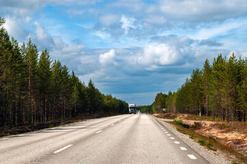 Empty wide road in the forest in the north of Europe in Sweden.