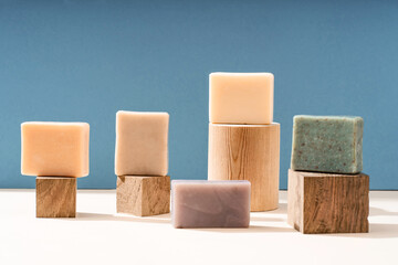 Pattern natural handmade soap of different sizes and colors. Brown background shadows of flowers from the sun. Cosmetic pedestal for product promotion.