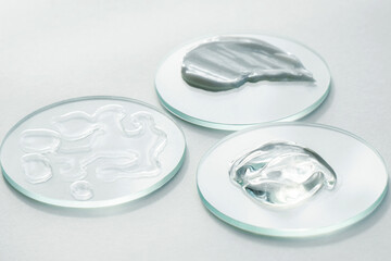 Glass petri dishes and glass pipette various cosmetic products cream gel, medical research. Cosmetic white background.