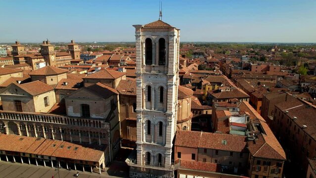 Ferrara Italy aerial drone view of Castello Estense castle and Piazza Savonarola square, medieval old town red tile roofs skyline, orbit over city center landmarks in Emilia Romagna, Italian history