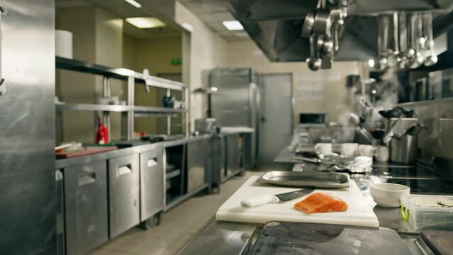 Professional kitchen in a hotel restaurant a piece of fresh salmon lies on a cutting board with a knife
