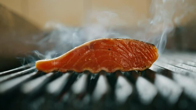 A professional kitchen in a hotel restaurant close-up of a juicy piece of fresh salmon on the grill