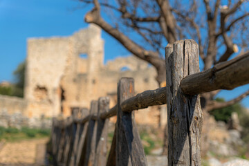 Historic architecture and an aged tree stand guard with a protective fence, preserving the past from uncertainty. Mersin, Turkey.