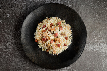 Rice dish with pieces of shank and bacon.