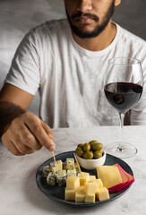 Man tasting wine and cheese.