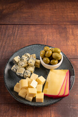Plate of various cheeses on the table. Pieces of cheese.