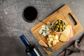 Plate of different cheeses with a glass of wine. Cheese board.