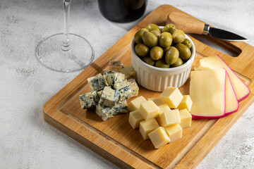 Plate of different cheeses with a glass of wine. Cheese board.