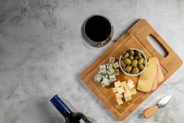 Plate of different cheeses with a glass of wine. Cheese board.