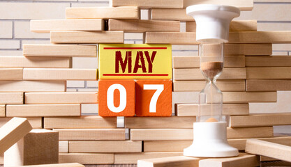 7 Mai on wooden grey cubes. Calendar cube date 07 May. Concept of date. Copy space for text or event.