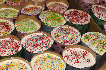 Easter Cakes decorated with white sugar glaze staying in raws. Traditional Easter baking on festive table.Selected focus