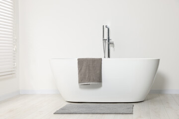 Naklejka na ściany i meble Stylish bathroom interior with ceramic tub and terry towel